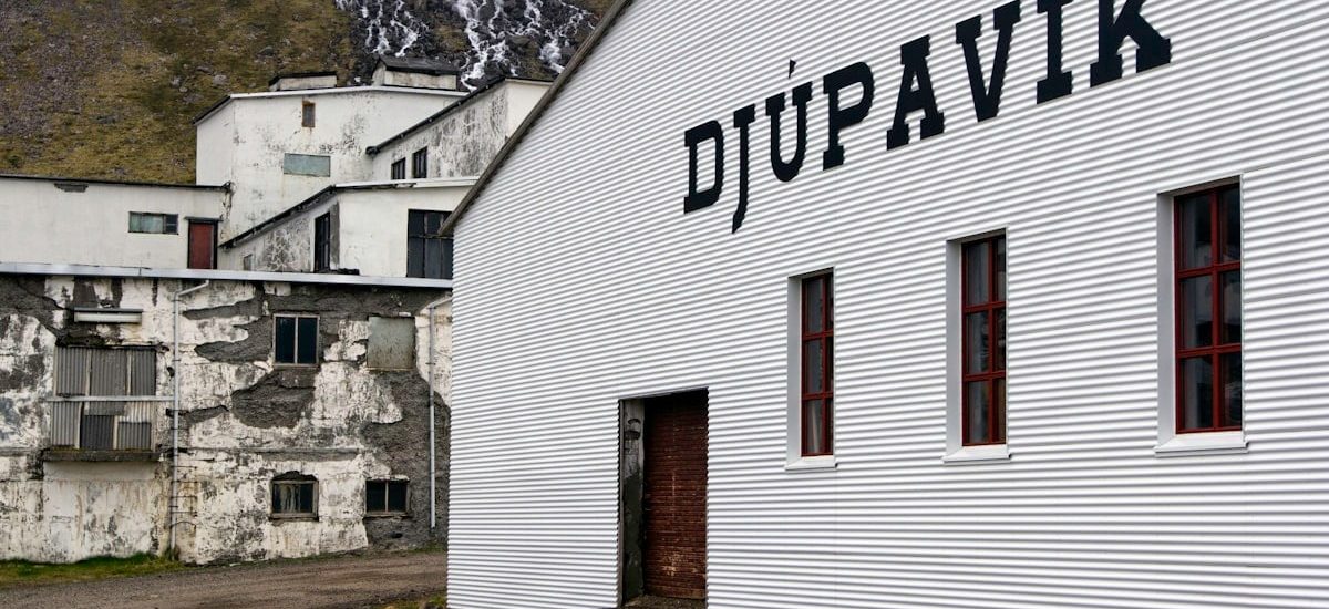 A white building with a sign on the side of it