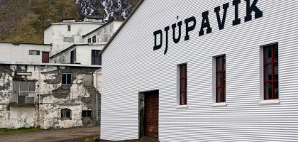 A white building with a sign on the side of it