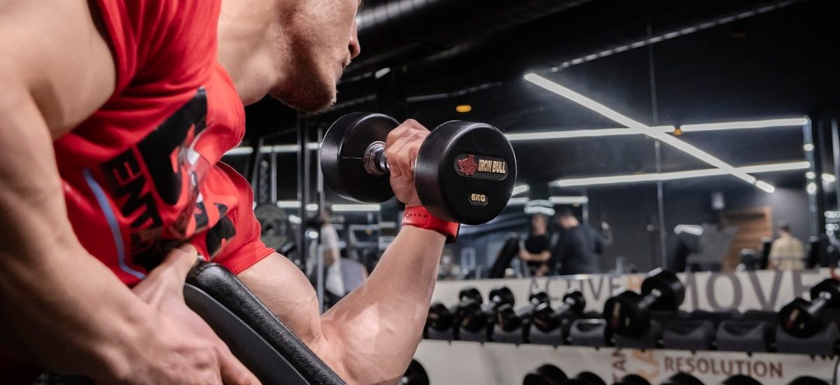 a man lifting a dumbbell in a gym
