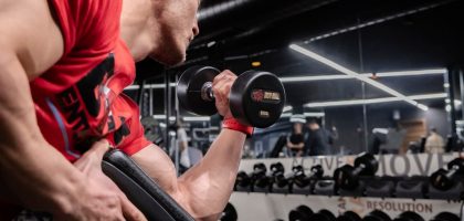 a man lifting a dumbbell in a gym