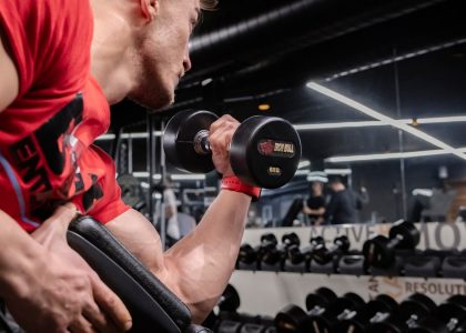 a man lifting a dumbbell in a gym